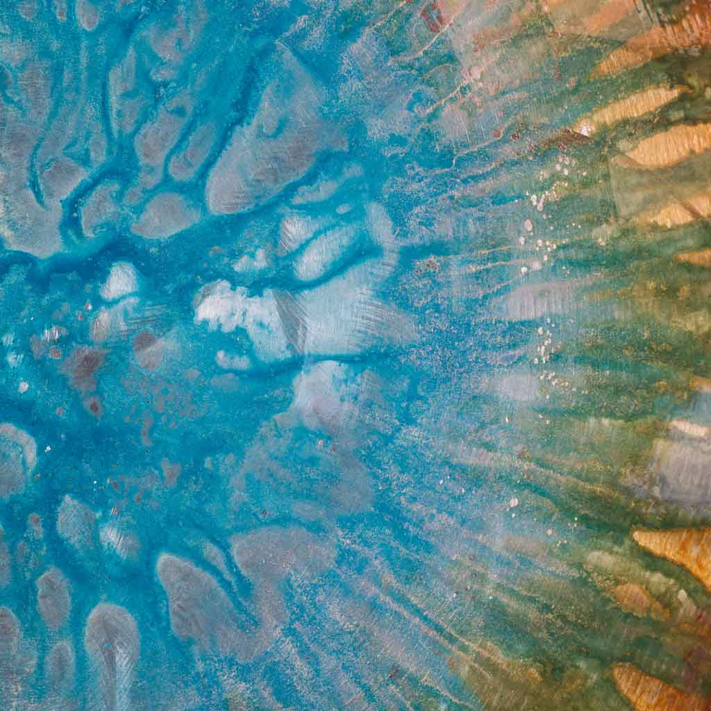 detail view of blue and green colorful circular wall sculpture